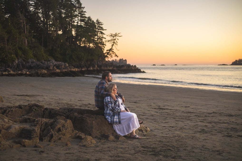 Couple watching the sunset at the beach in tofino during their elopement