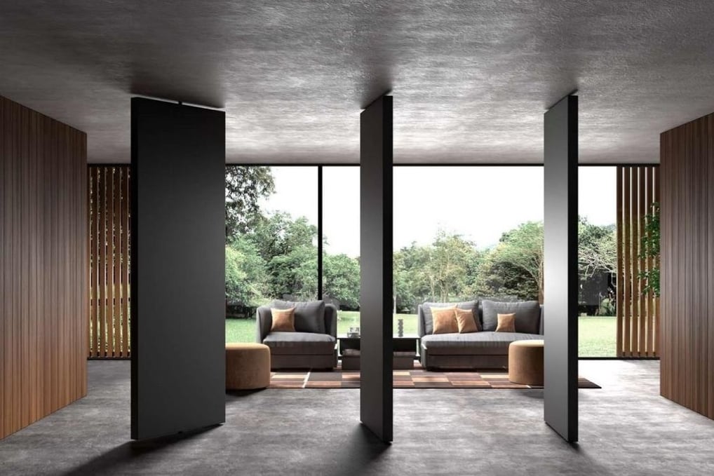 Acceso interior con puerta pivotante de diseño moderno y estructura metálica en entorno profesional