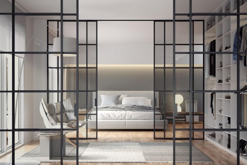 Puerta de vidrio corredera con marco negro en espacio diáfano entre salón y dormitorio contemporáneo