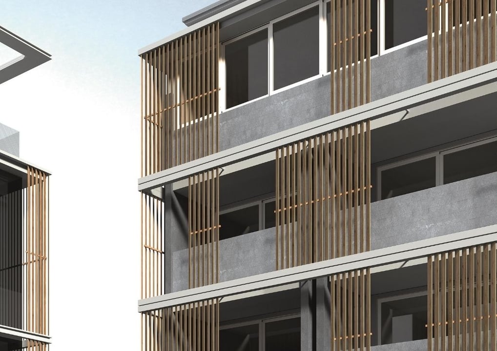 Edificio multifamiliar con balcones amplios y fachada ventilada con revestimiento de madera clara