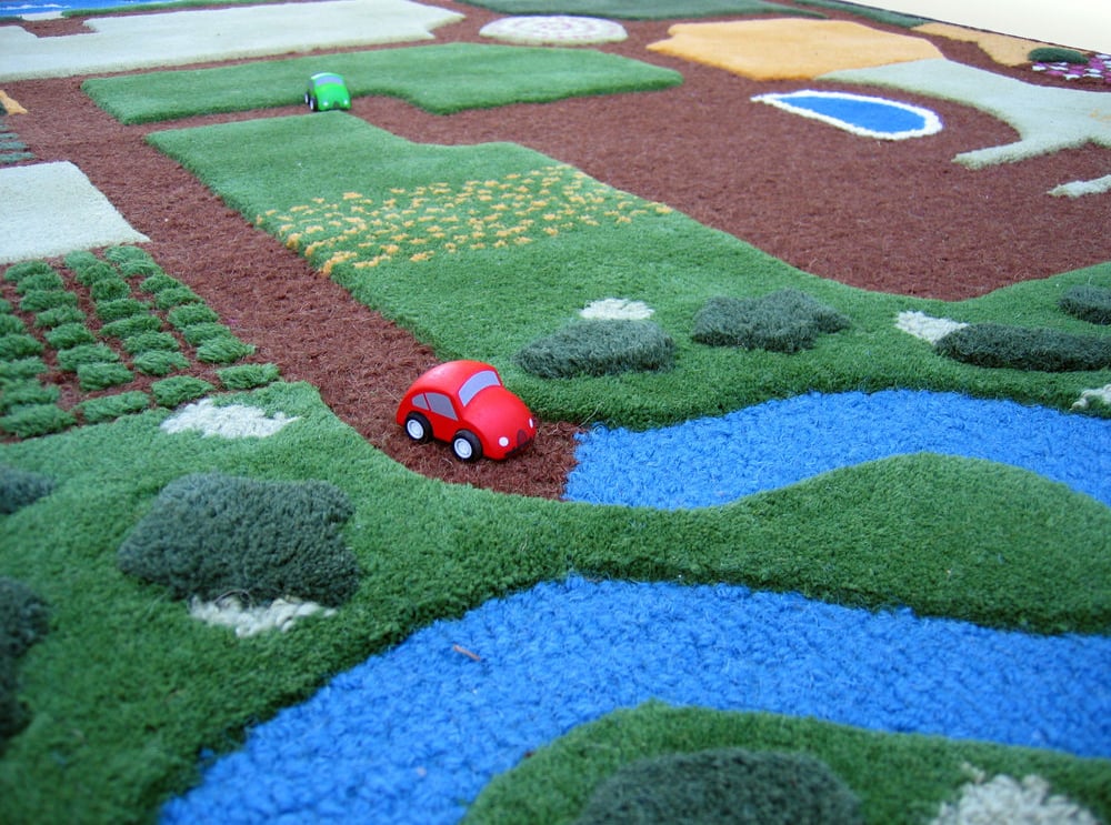 Wooden toy car on woolen play carpet