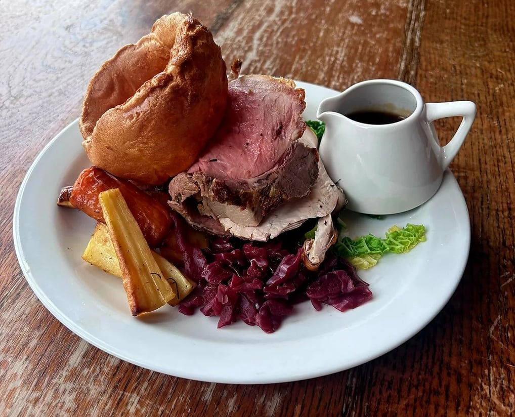 a plate of food with a mug of gravy 