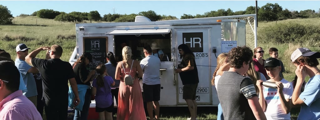 White food truck serving food to a crowd