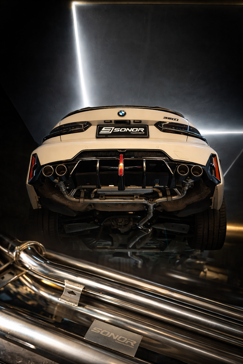 White BMW 320i featuring a Sonor performance exhaust system with quad tips and rear diffuser.