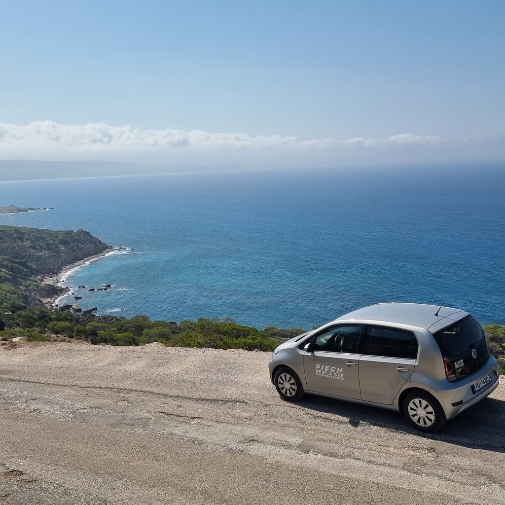 Siech rental car parked on a scenic coastal cliff overlooking the blue Mediterranean sea.