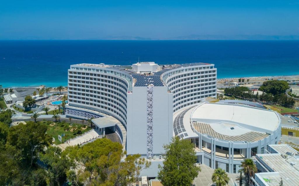 Aerial view of a luxury beachfront hotel resort with solar panels and ocean views.