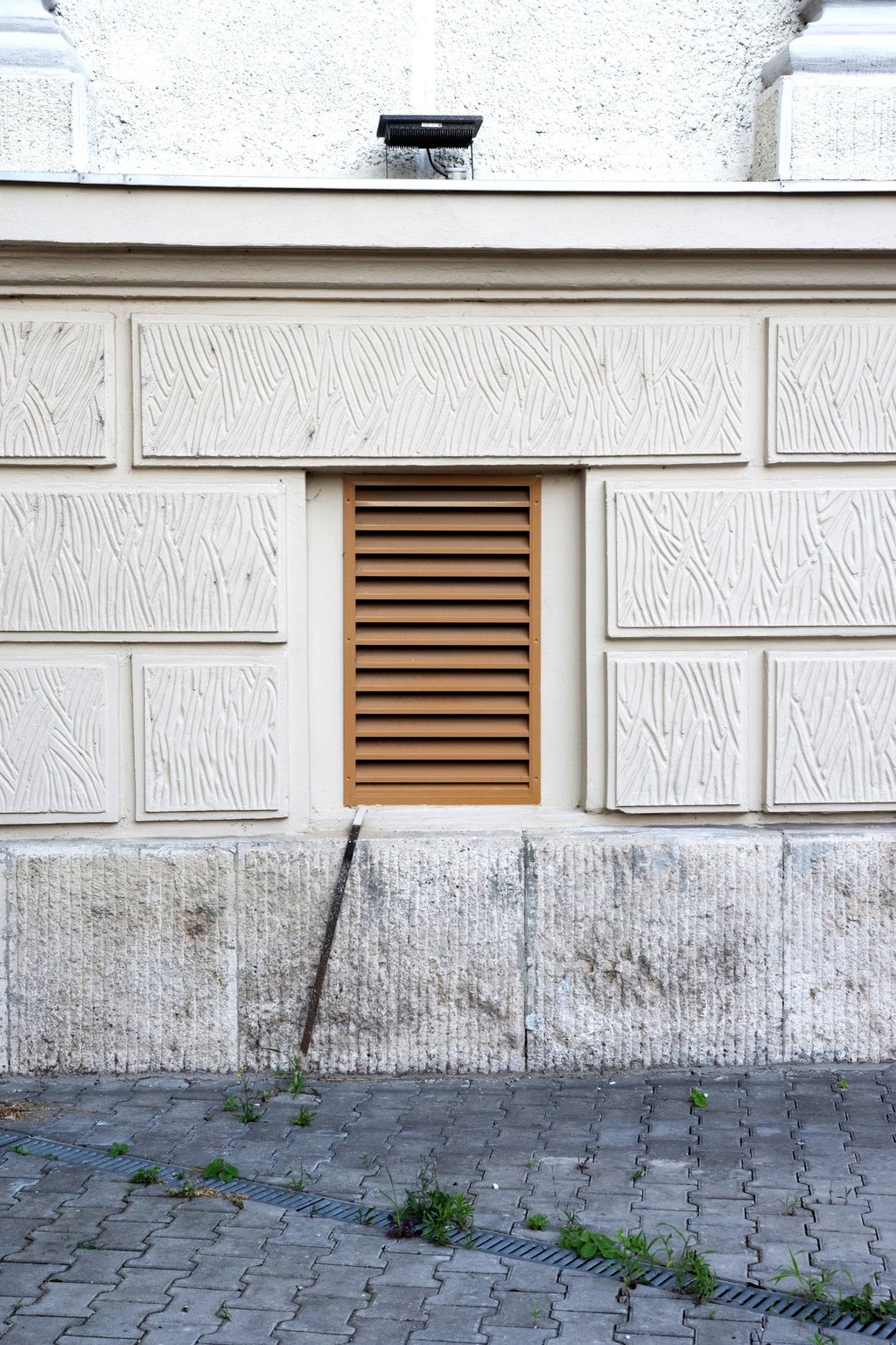 Mur en pierre texturée orné de panneaux rectangulaires décoratifs sale.