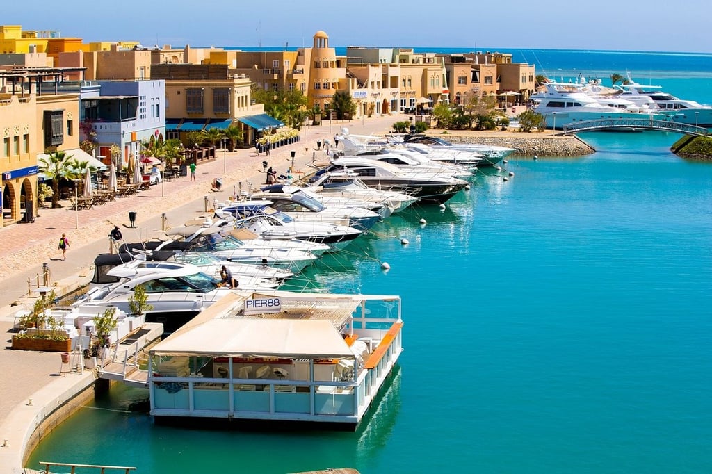 Luxury yachts and speedboats docked in the turquoise water at El Gouna Marina, Egypt.