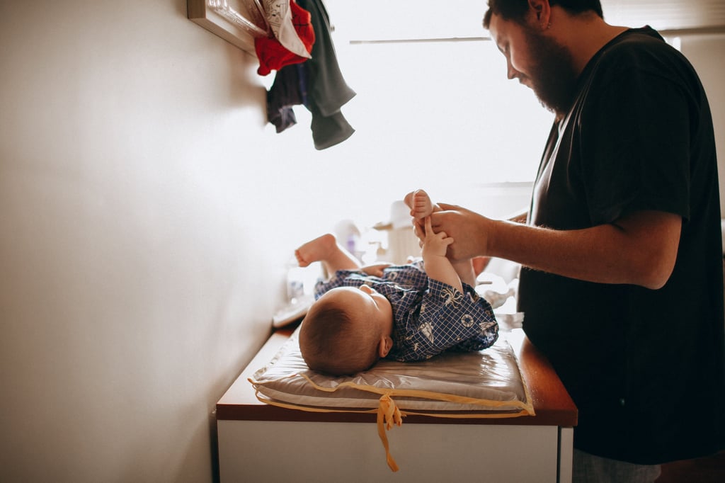 Nouveau papa changeant la couche de son bébé à la maison" 