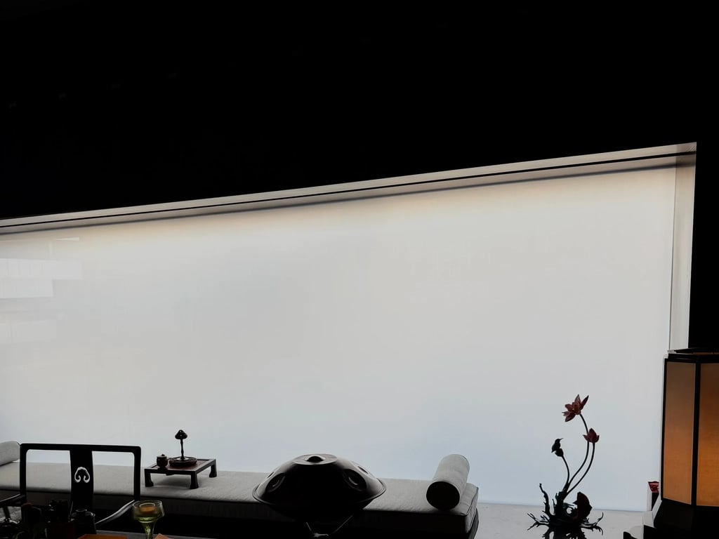 Minimalist meditation room featuring a steel tongue drum and floral decor against a large frosted window.