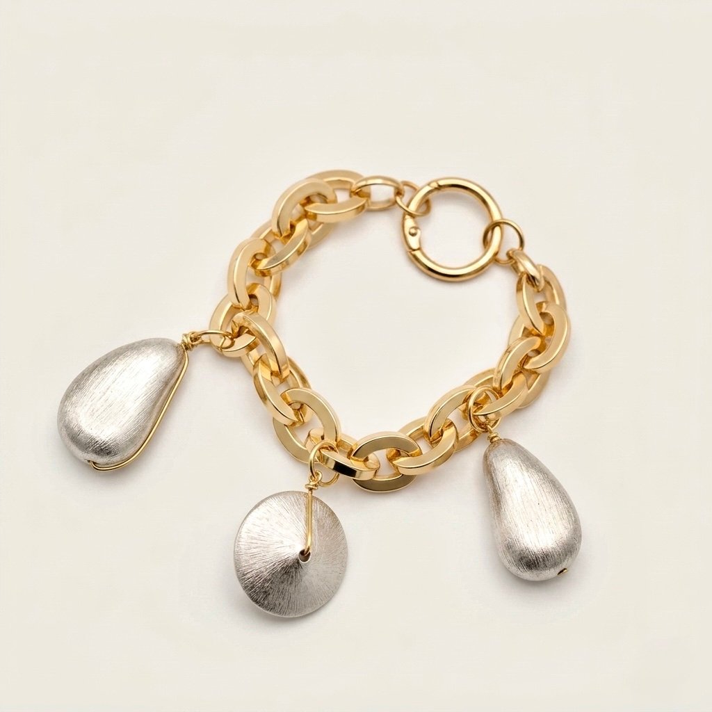 Elegant gold chunky link charm bracelet featuring brushed silver teardrop and disc pendants.