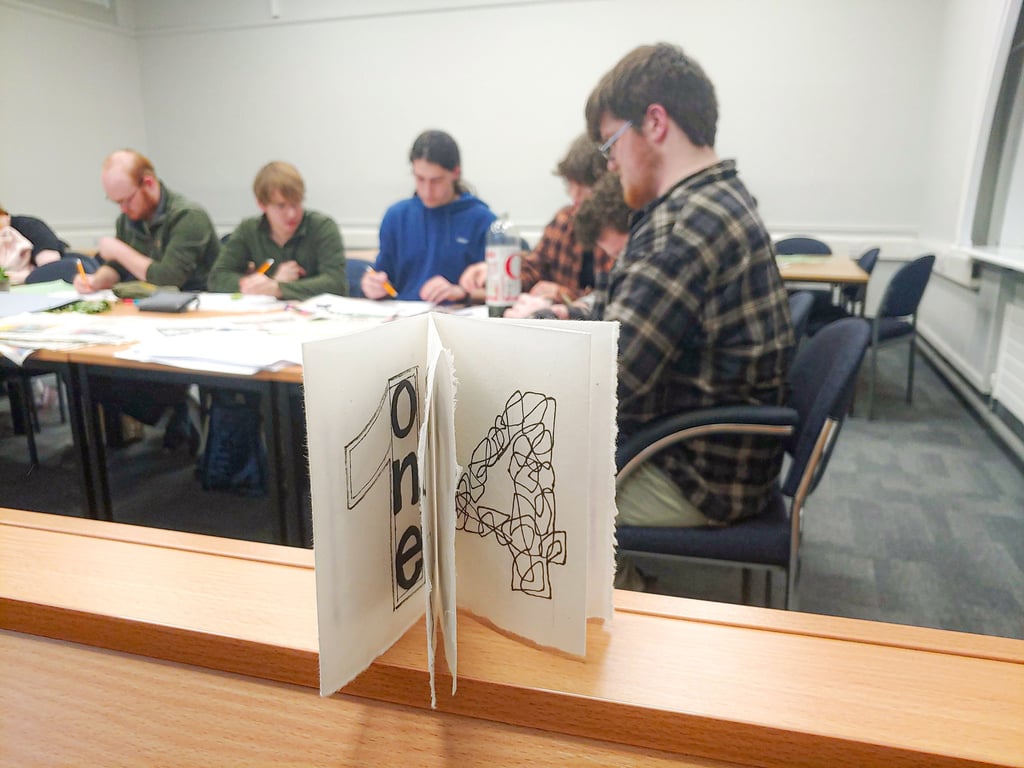 Eight-page zine with a group of participants drawing in the background