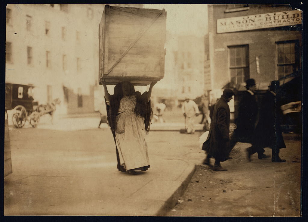 Historic photo of a woman carrying box
