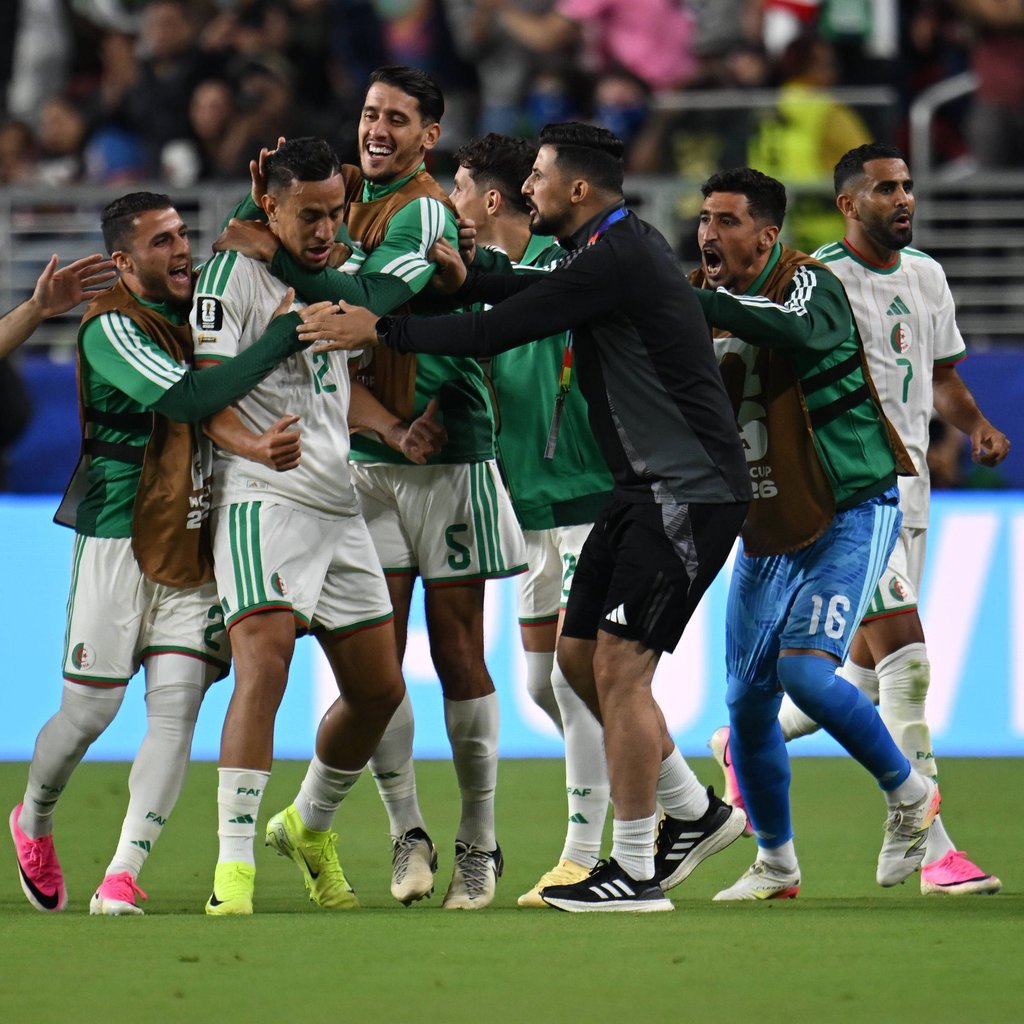 Algerian national football team players celebrate a goal on the pitch during an international match.