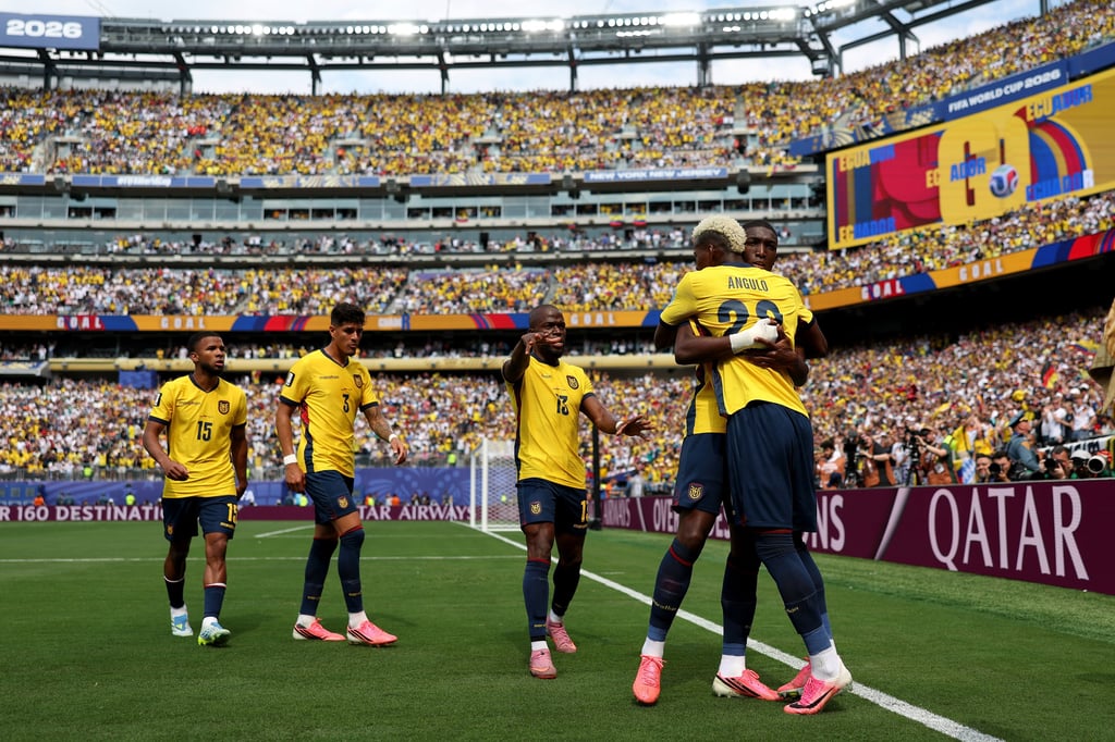 Ecuador national football team players celebrate a goal in a packed stadium during a FIFA World Cup 2026 match.