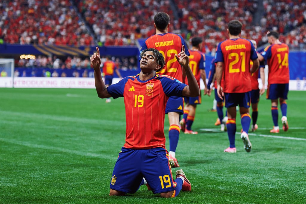 Spain national football team player Lamine Yamal celebrates on his knees during a match.