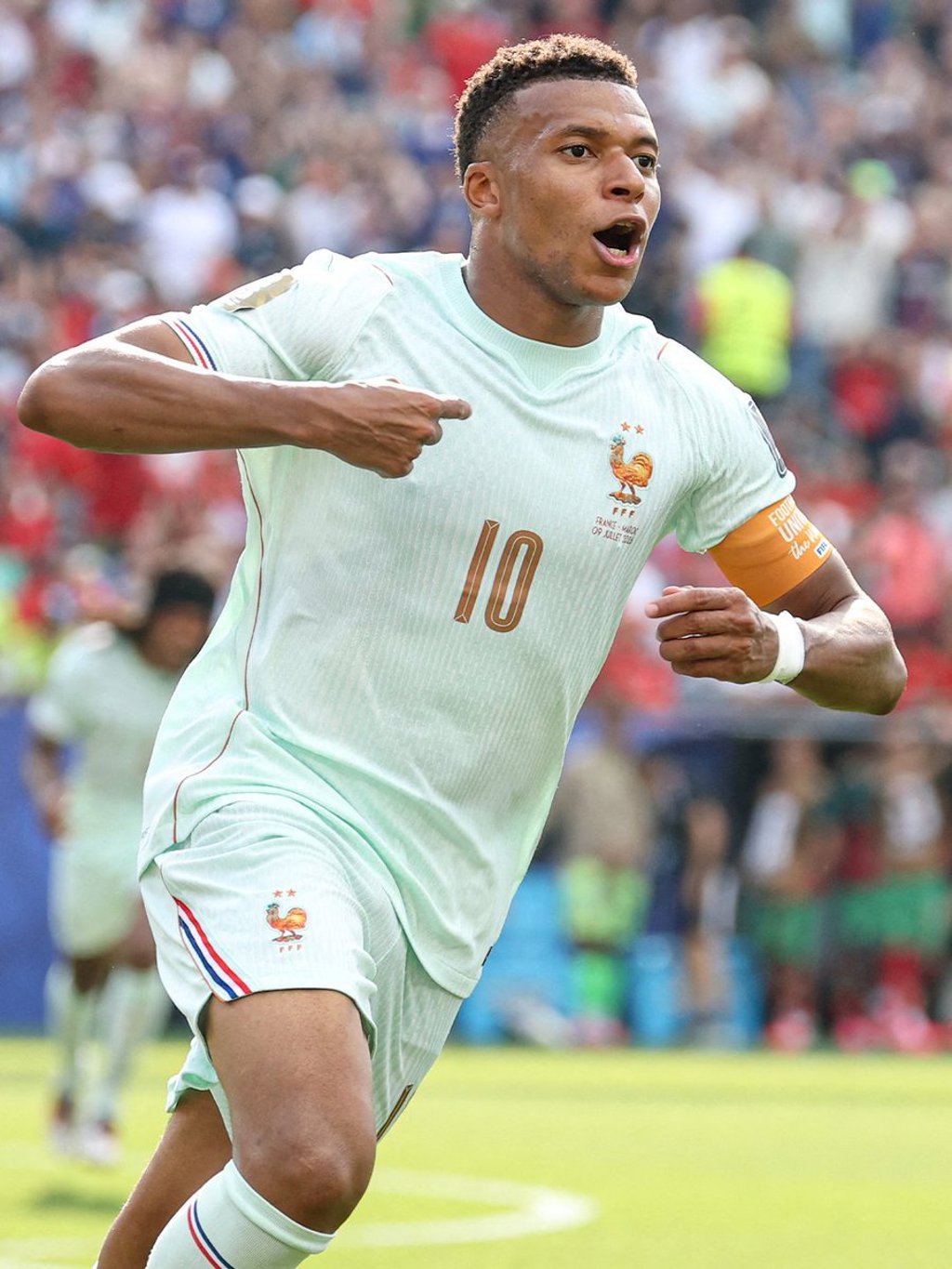 Kylian Mbappe celebrates on field in France national football jersey number 10 during a soccer match.