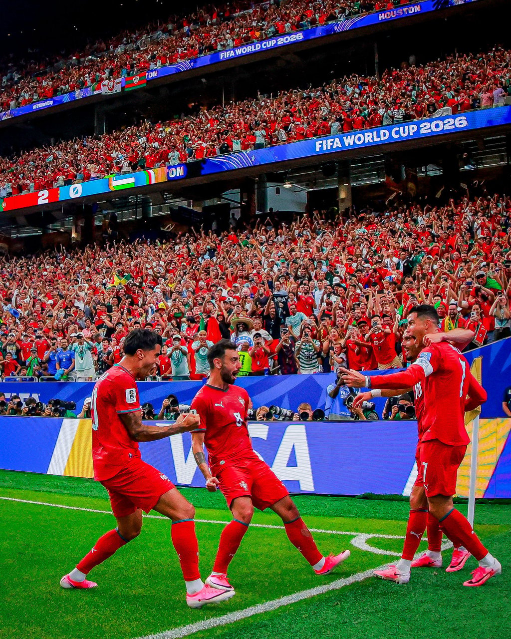 Portuguese soccer players celebrate a goal in front of a massive crowd during a FIFA World Cup 2026 match.