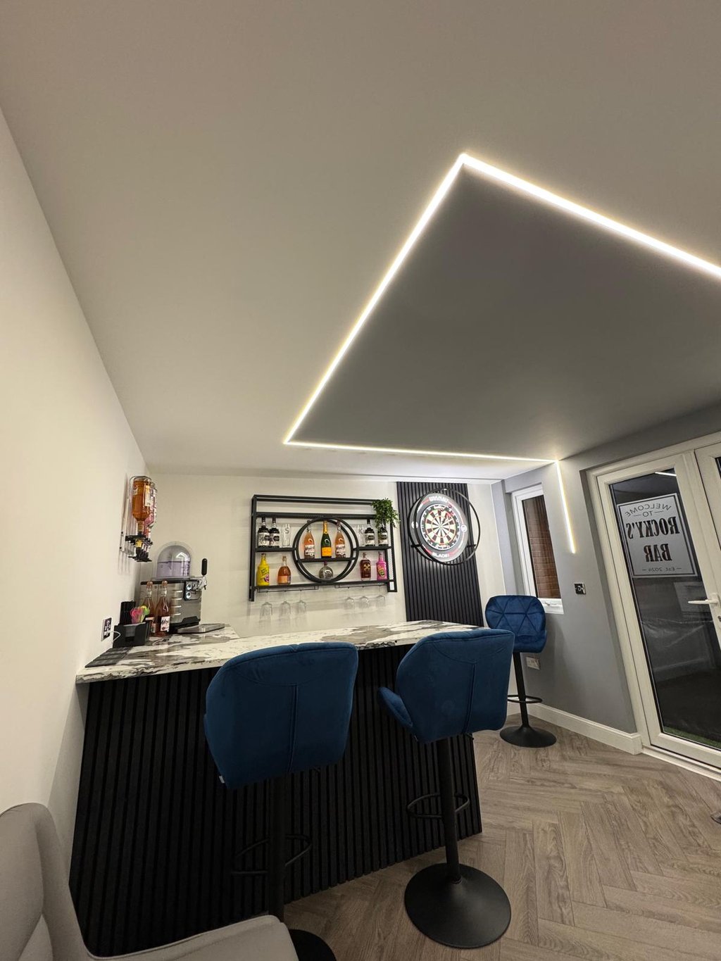 Custom garden room with feature lighting, bar, and dartboard