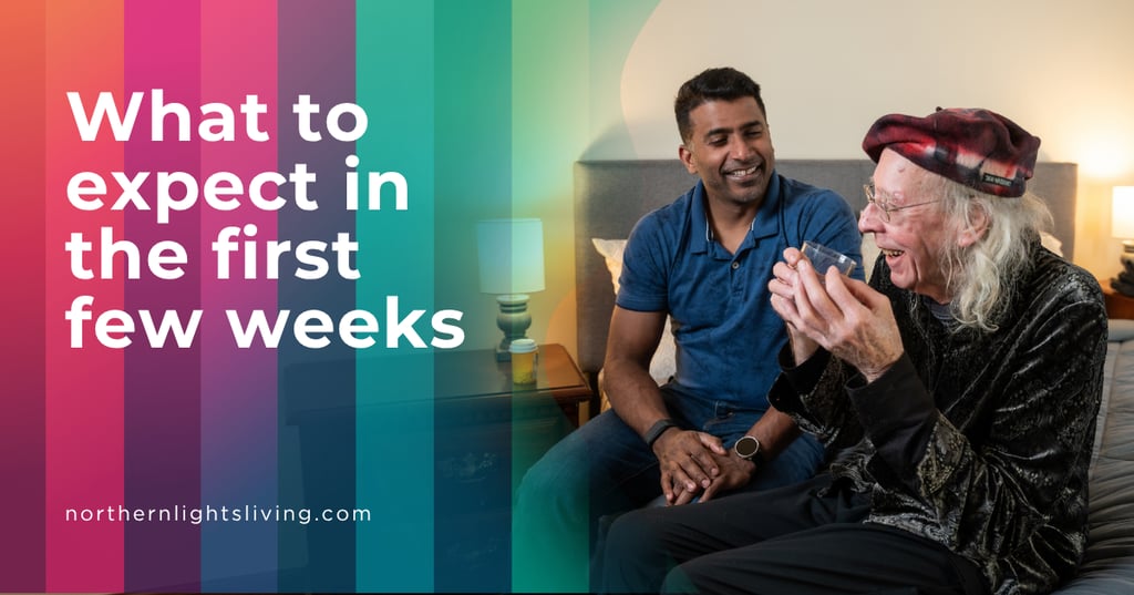 A caregiver smiling and sitting with a senior man in a bedroom, depicting senior care support services.