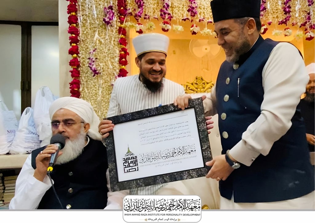 Religious scholars at the Imam Ahmad Raza Institute presenting a framed certificate with Arabic calligraphy.