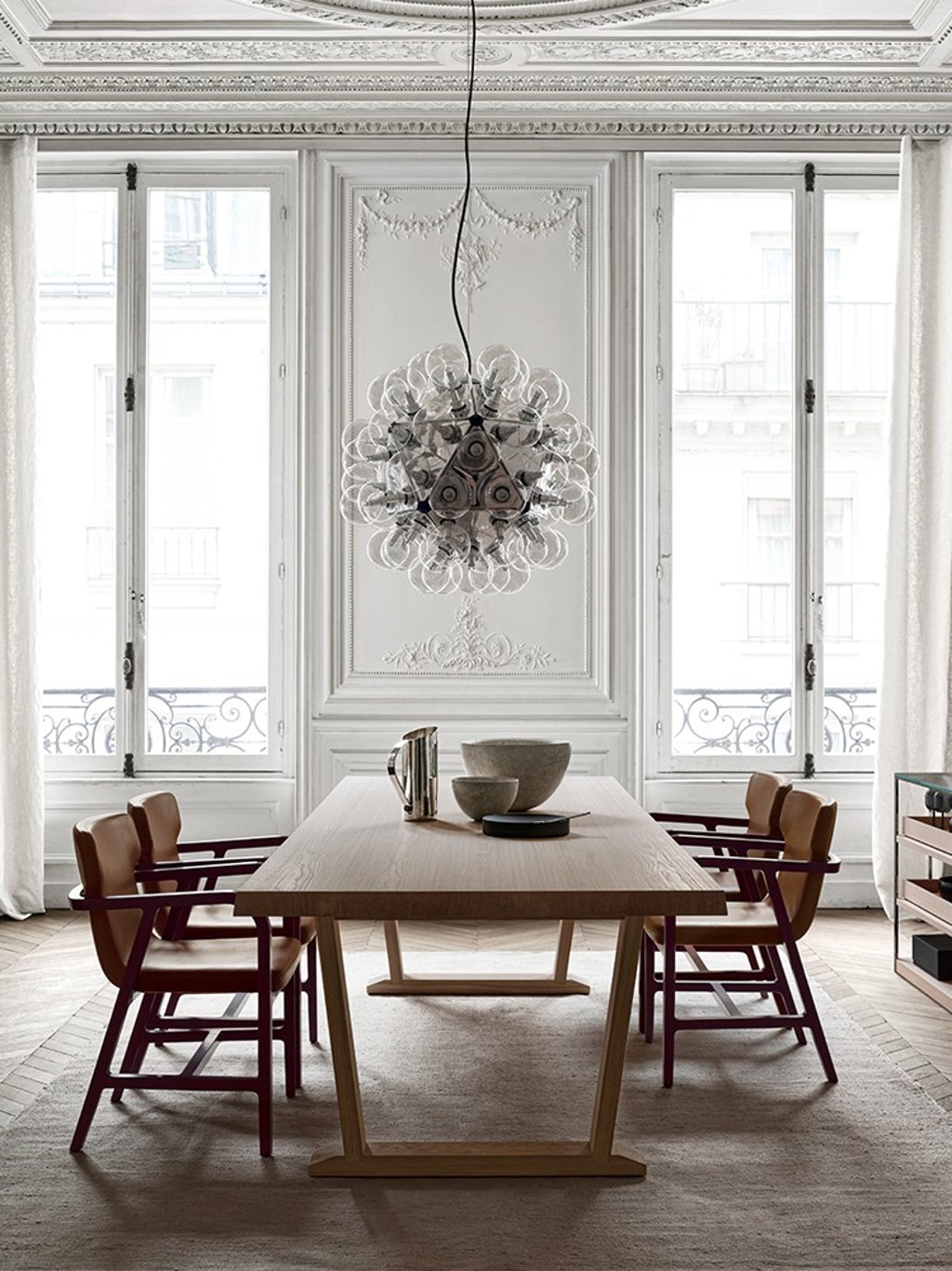 Maxalto dining table by Antonio Citterio in a Haussmann apartment with ornate plaster ceiling moldings