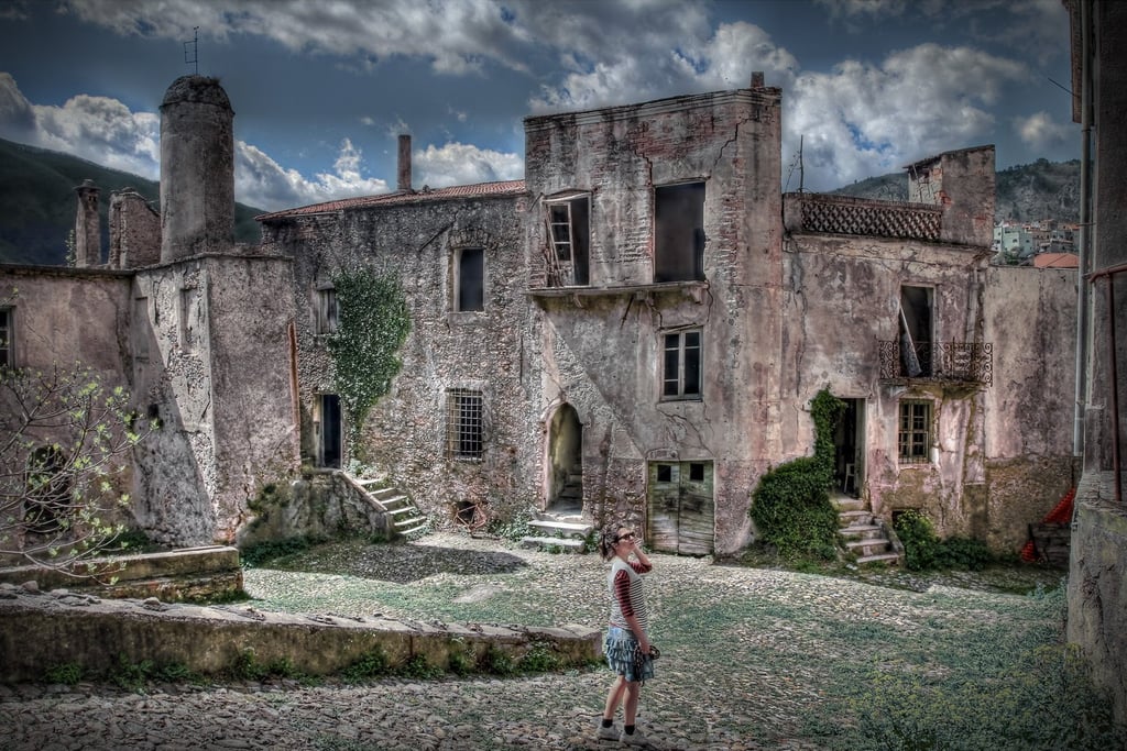 Erica Fossati standing in an abandoned historic Italian village assessing restoration potential