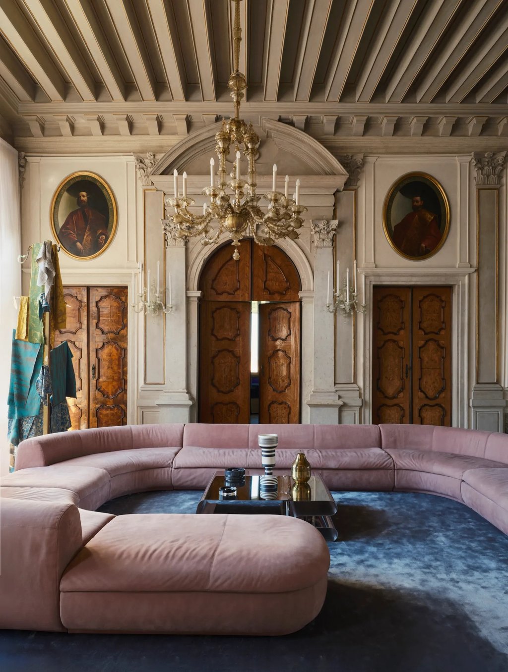 Venetian palazzo with Murano chandelier, ancestral portraits and a large curved contemporary pink sofa. Photo Simon Watson