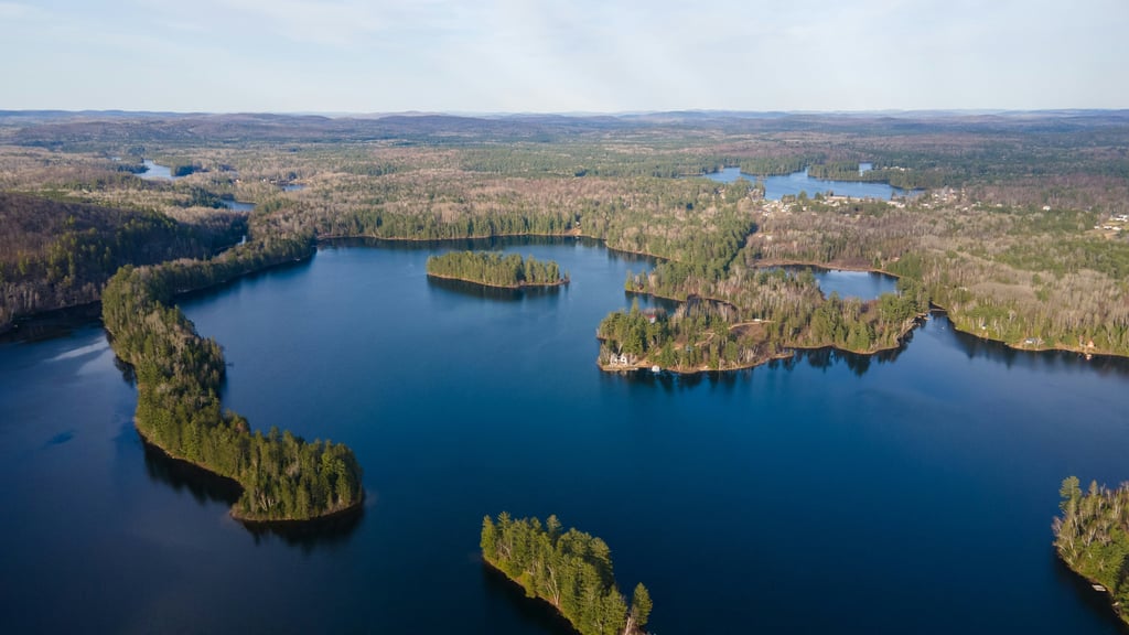Aerial view of Muskoka lakefront and shoreline cottages.