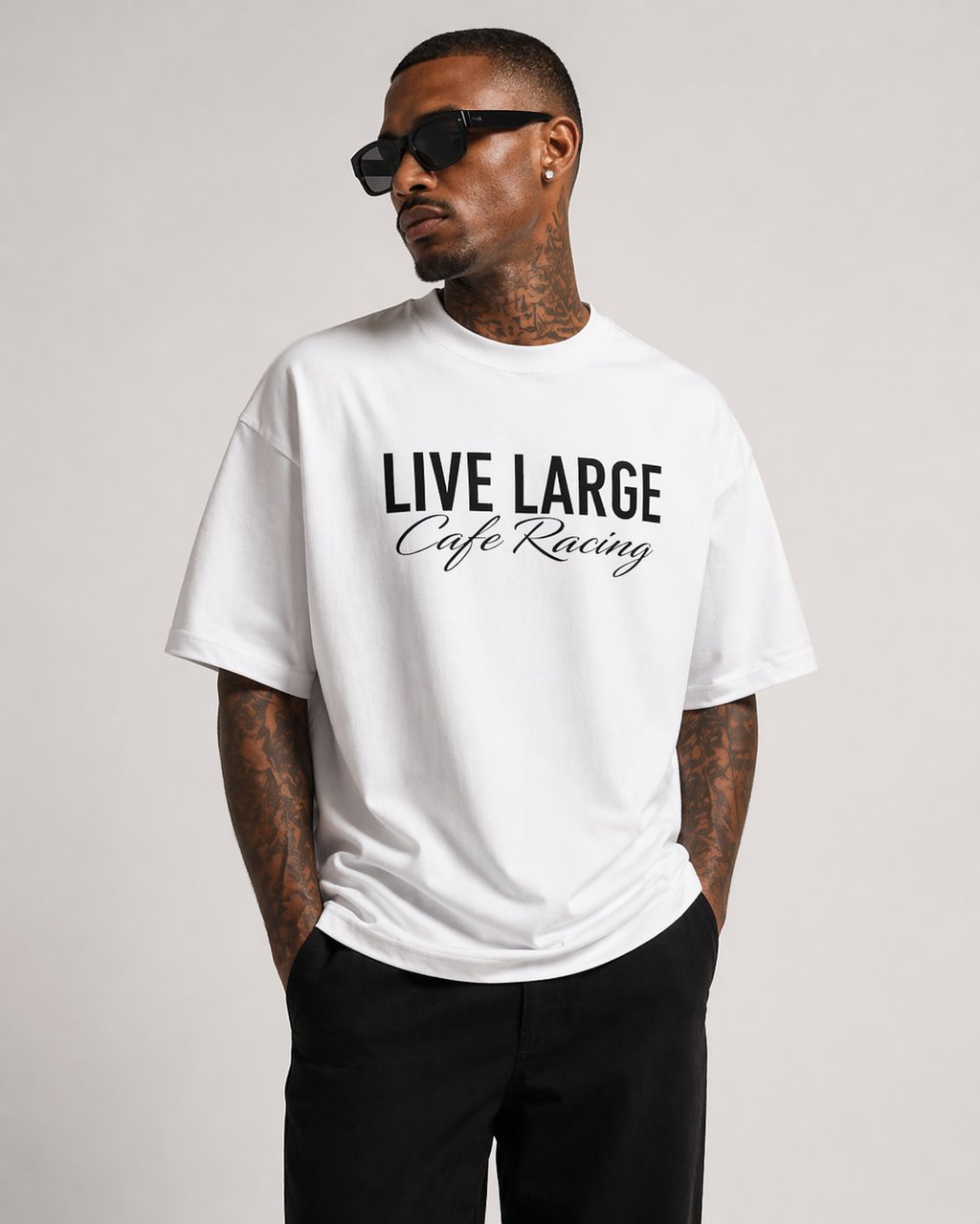 Man wearing a white Live Large Cafe Racing graphic t-shirt with black sunglasses.