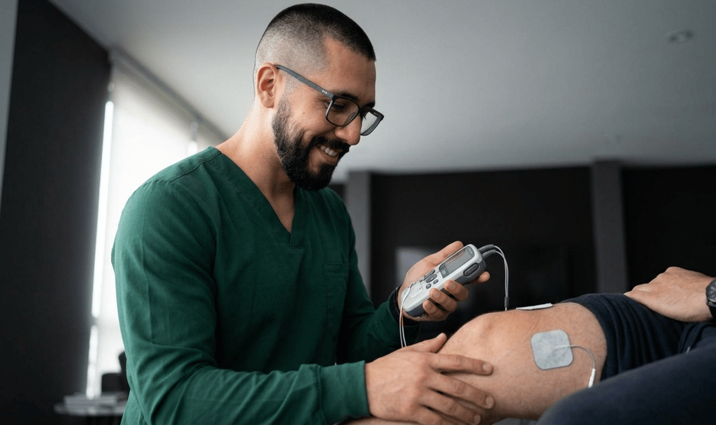 fisioterapeuta utilizando FES para atendimento de fisioterapia domiciliar