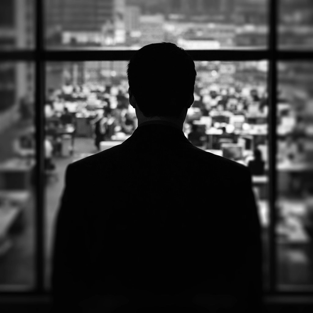 a manager looking down a large working room full of employees