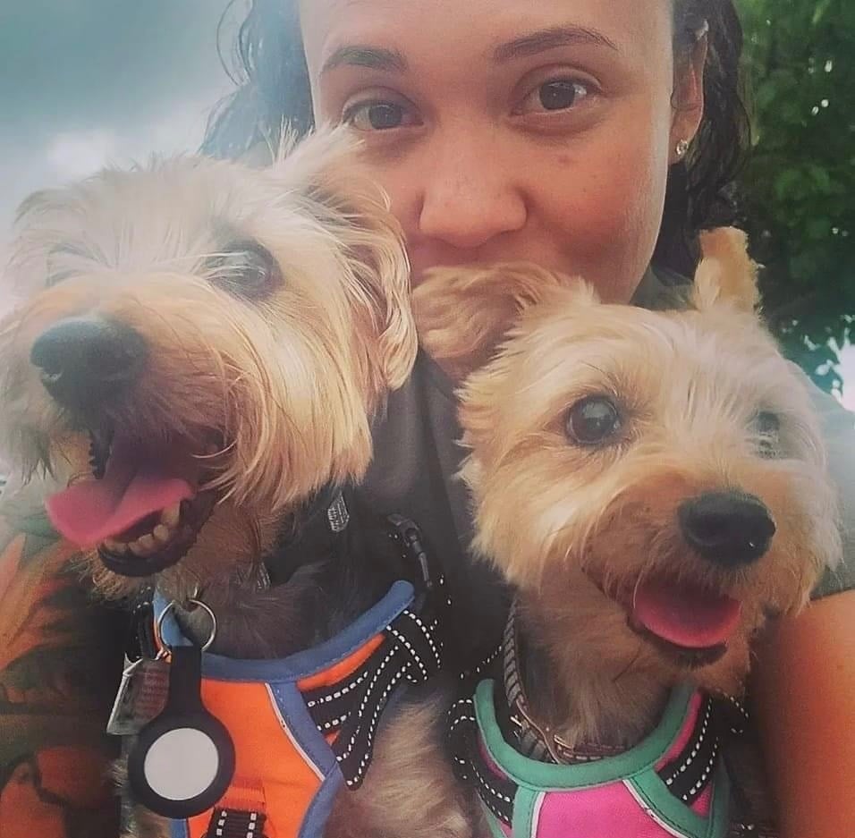 a woman holding two dogs in her arms