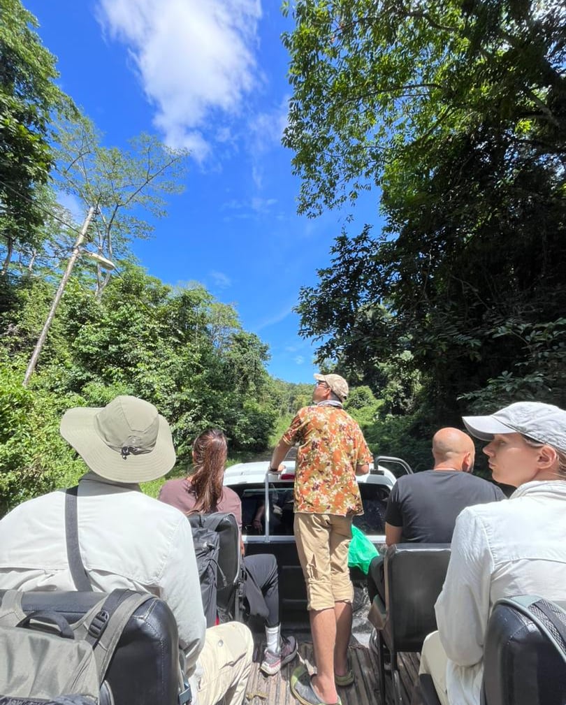 a group of people inside safari car looking for wildlife