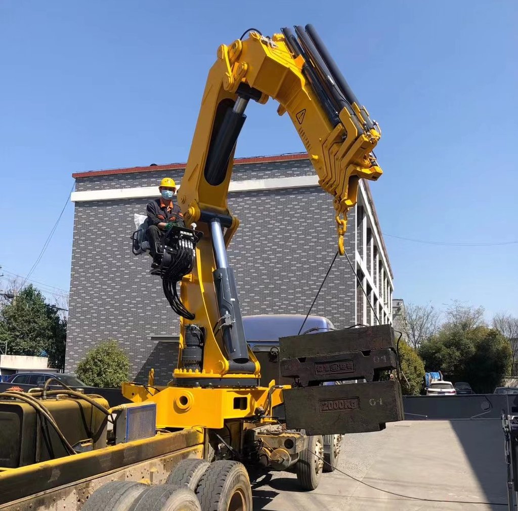 A large object being raised by a crane, specifically a 25 Ton Knuckle Loader Crane.