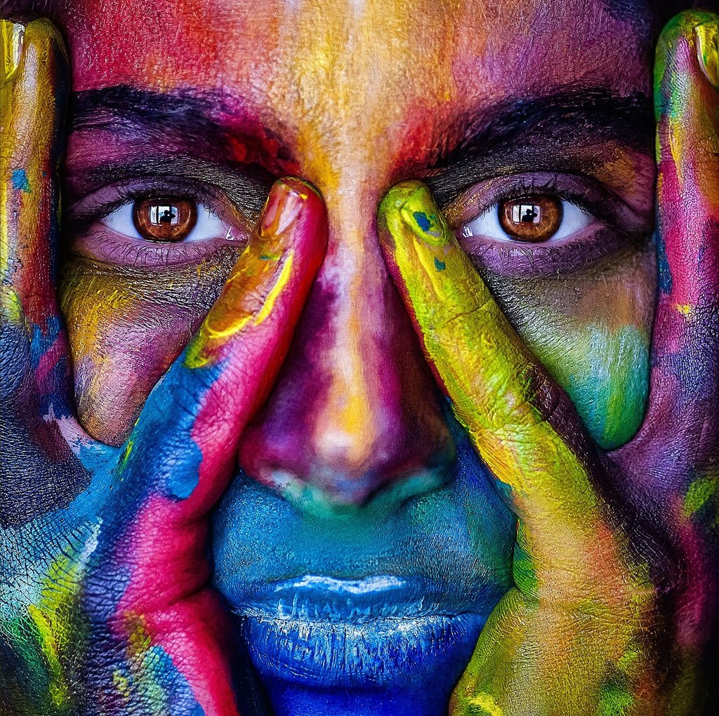 A man with painted hands on his face.