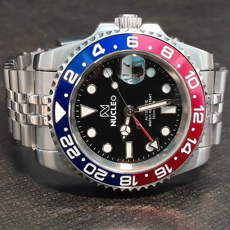 homage nucleo gmt2 master pepsi appoggiato su un piano nero con la corona rivolta in alto