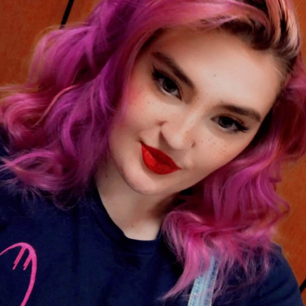 a woman with pink hair and a blue shirt