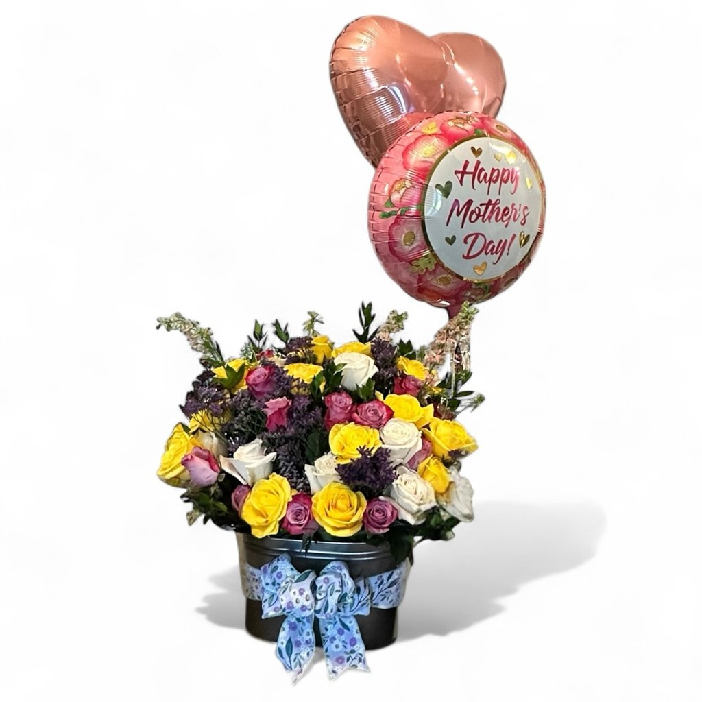 Floral arrangement for mothers day.  Main flowers are pink, yellow, and white roses
