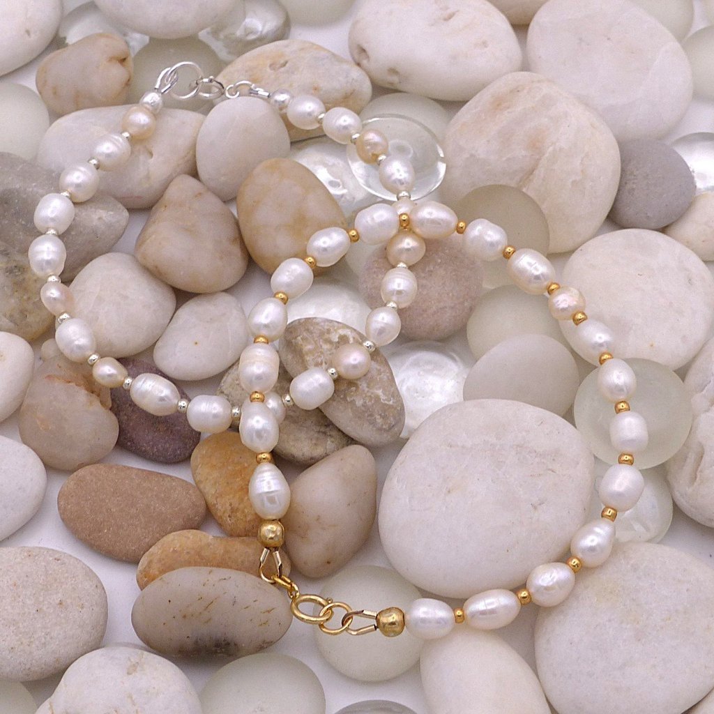 Elegant handmade freshwater pearl bracelets with gold and silver accents on smooth river stones.