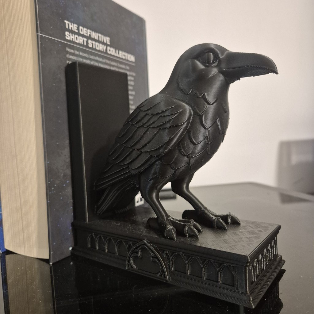 Un serre-livre corbeau soutenant un livre volumineux