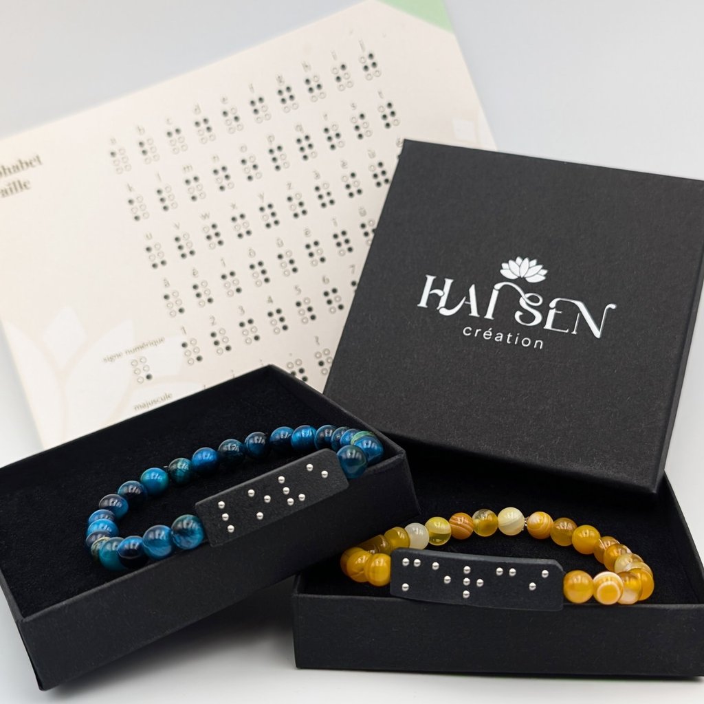 Bracelets perles avec plaques en braille, dans un écrin noire accompagné d'un alphabet braille.