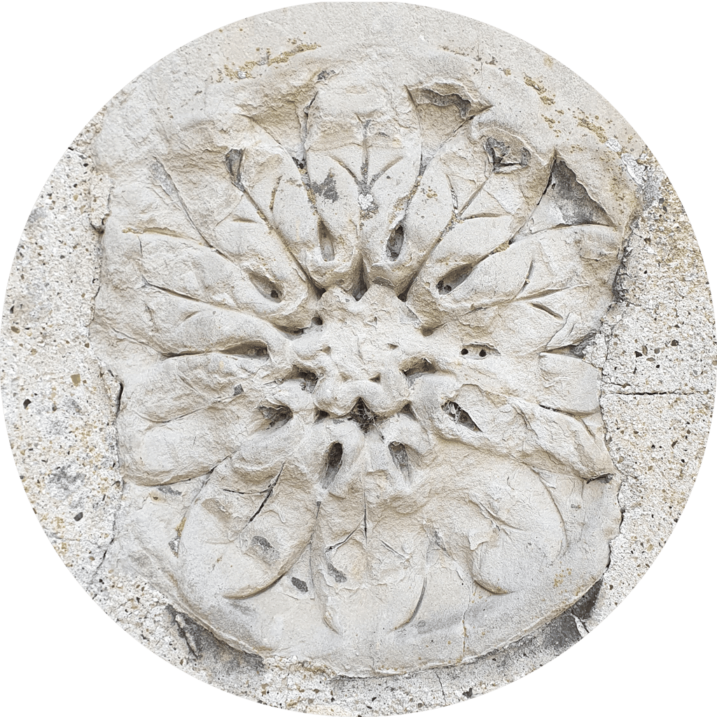 A 12-fold rosette of leaves in masonry, set roughly in mortar.