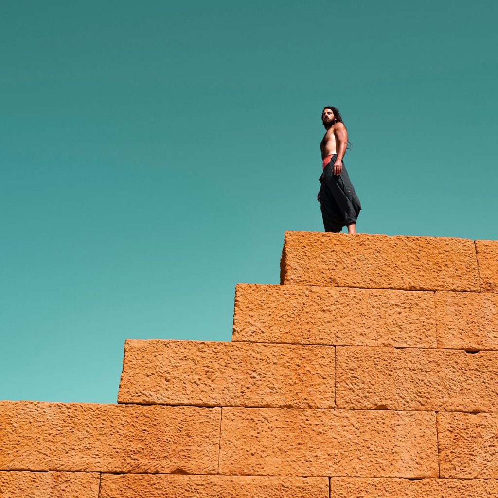 a man standing on a brick wall 