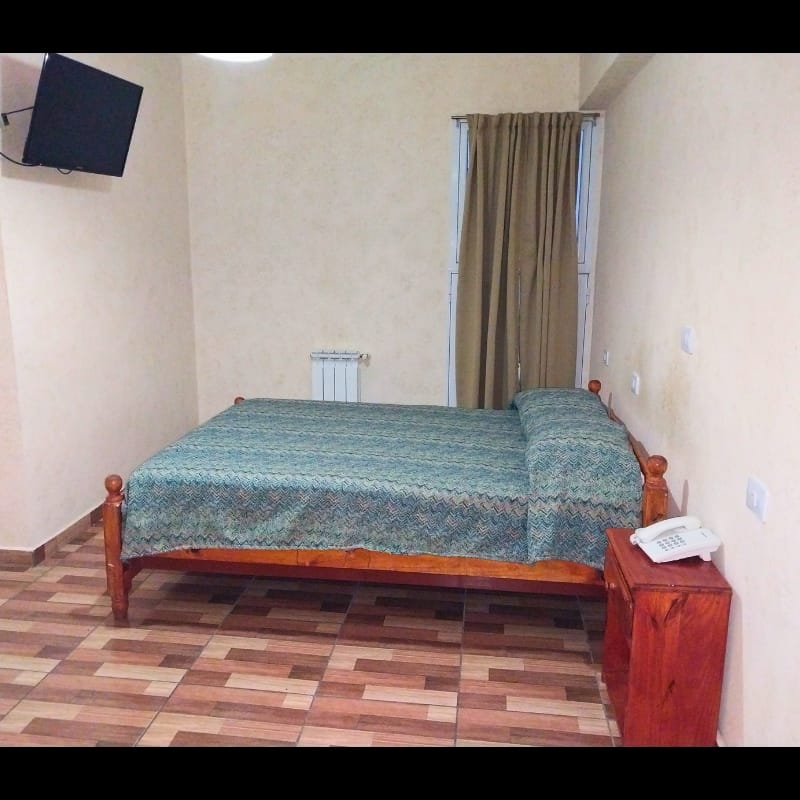 Una habitación con una cama y un televisor