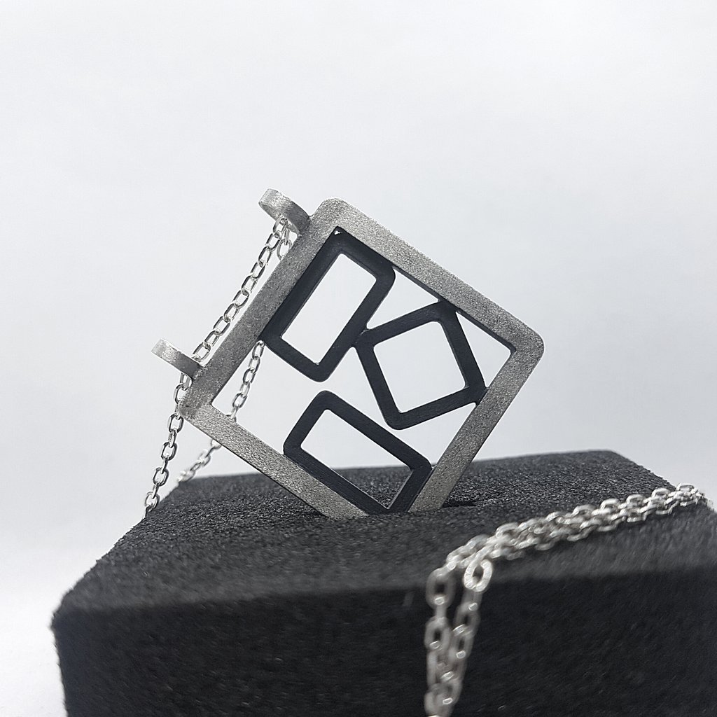 a square shaped pendant with a geometric design
