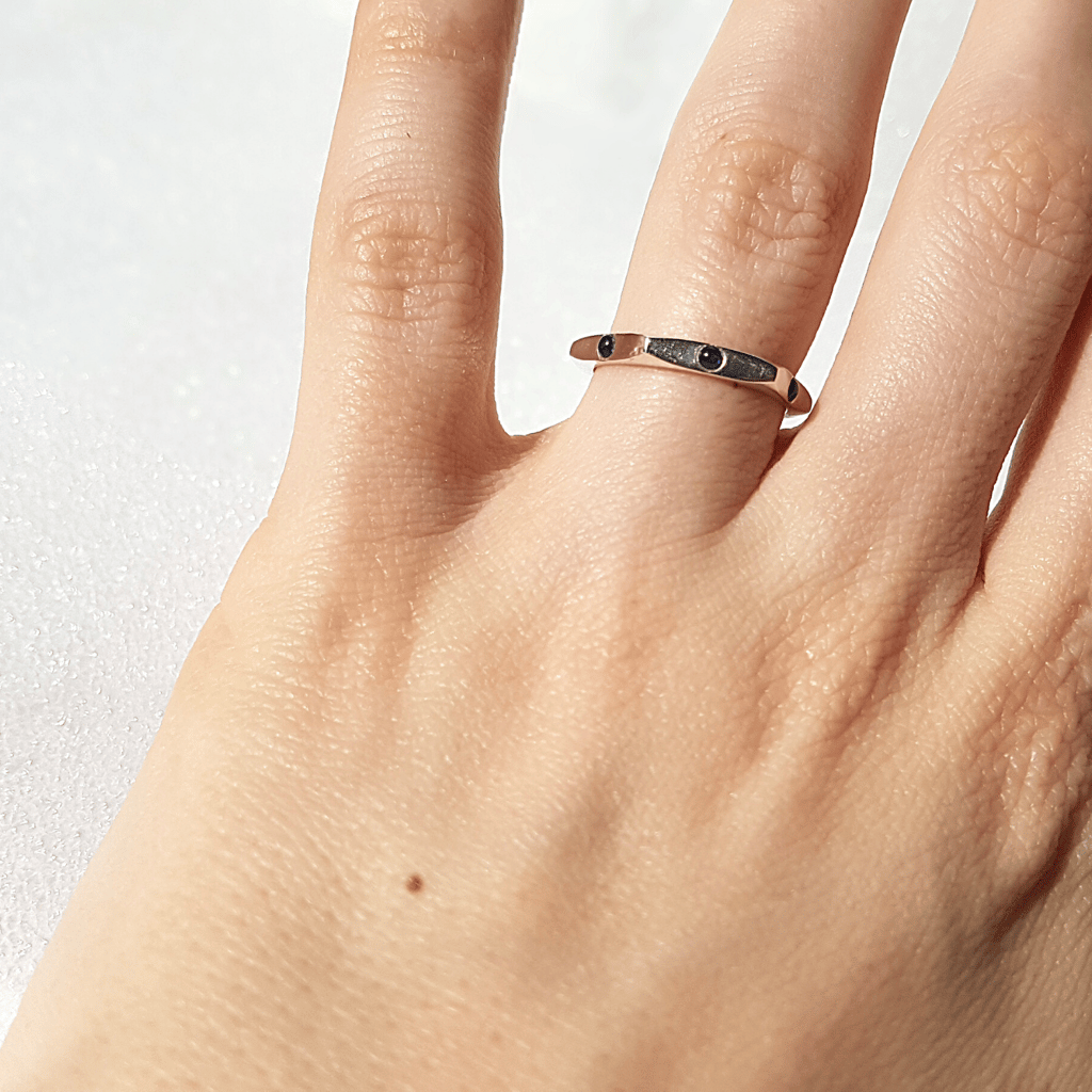 Elegant sterling silver ring with small blue sapphire gemstones, handcrafted for women, showcasing a minimalist design on a