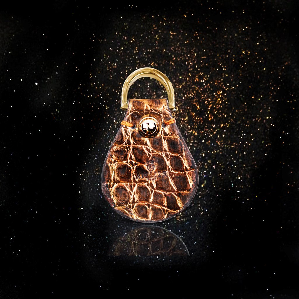 Luxurious genuine brown alligator leather key holder on a sparkly black background, reflecting elegance and craftsmanship.