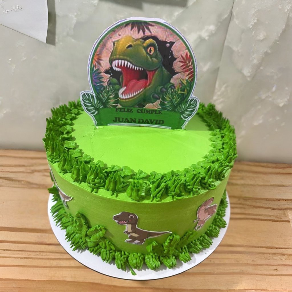 Pastel de cumpleaños de dinosaurio verde personalizado con un adorno T-Rex y detalles de glaseado de
