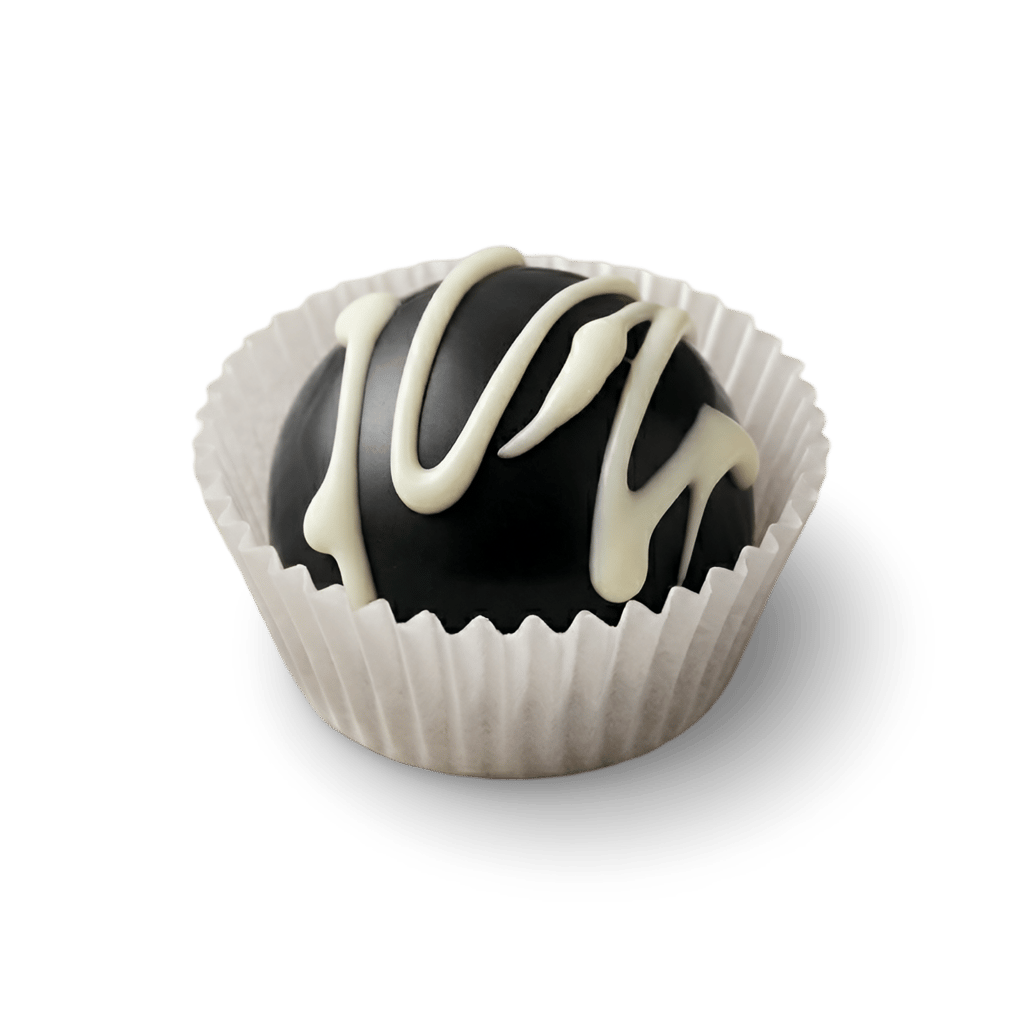 Handcrafted dark chocolate truffle with white chocolate drizzle in a paper cupcake liner.